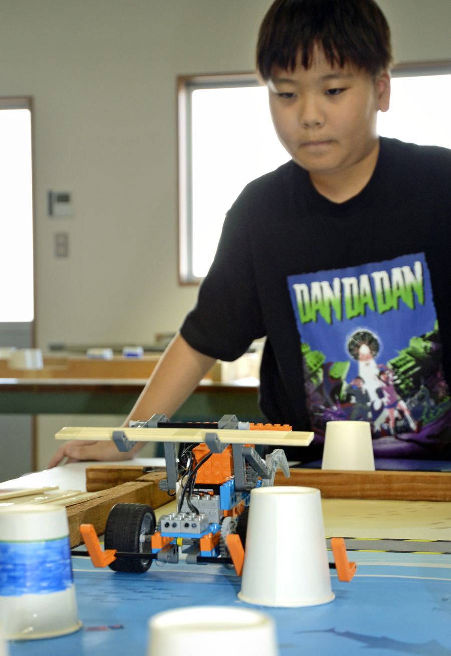 プログラミングしたロボットを使って競技を楽しむ子どもたち（南国市の「からくり創造工房」）