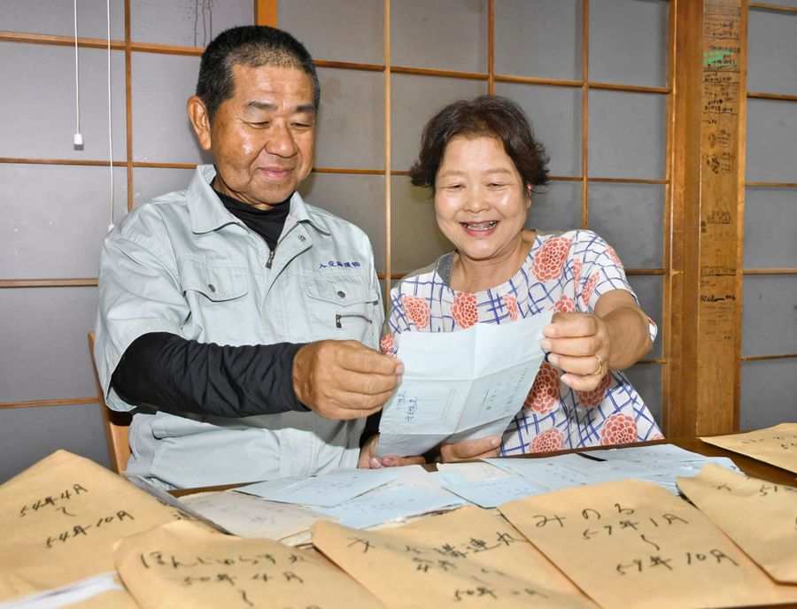 「お互いに届くのを心待ちにしてたねぇ」と笑顔で手紙を読む中平さん夫妻（土佐市宇佐町）