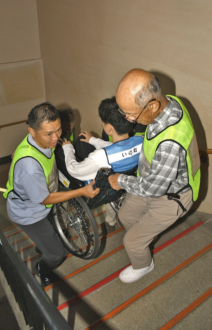 避難訓練で車いす利用者への対応を学ぶ参加者（写真はいずれもいの町の伊野公民館）