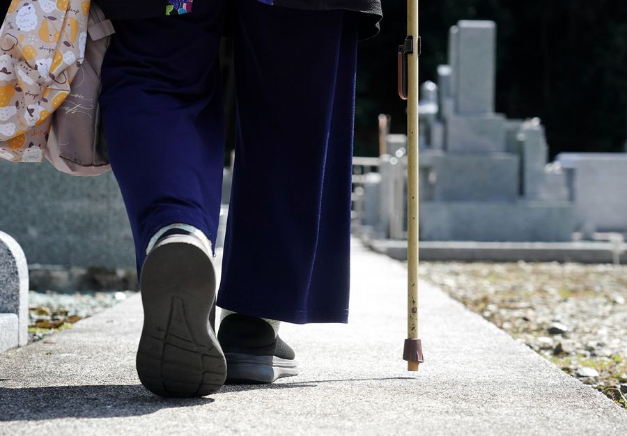 つえをついて契約した墓地を歩く女性(高知市内)