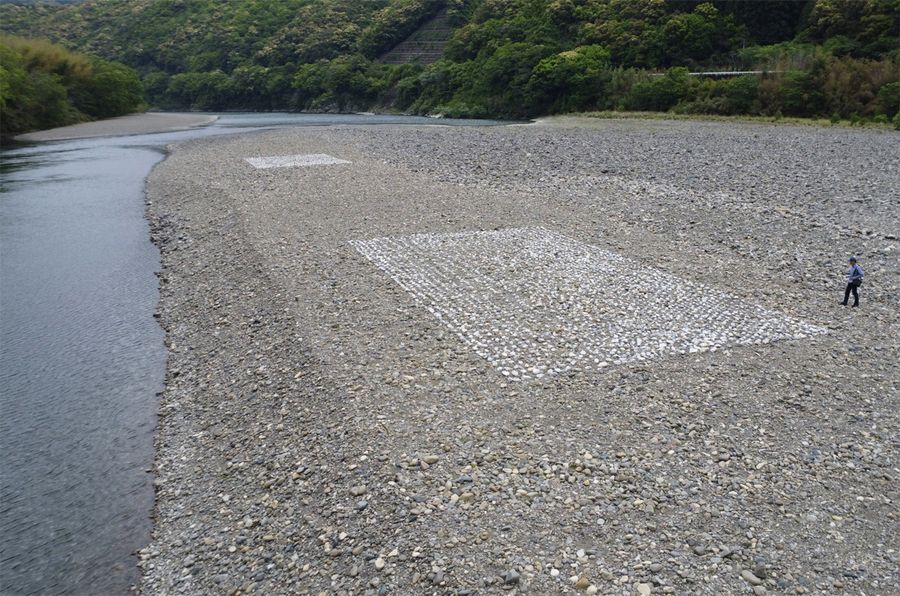 ダンプ９１５台分の石が水際に積まれた今年５月の状態。石の一部は、この後の大水で流れ下った。白い四角の部分は目印となる石灰石。川の流れは奥から手前へ（四万十市西土佐中半）