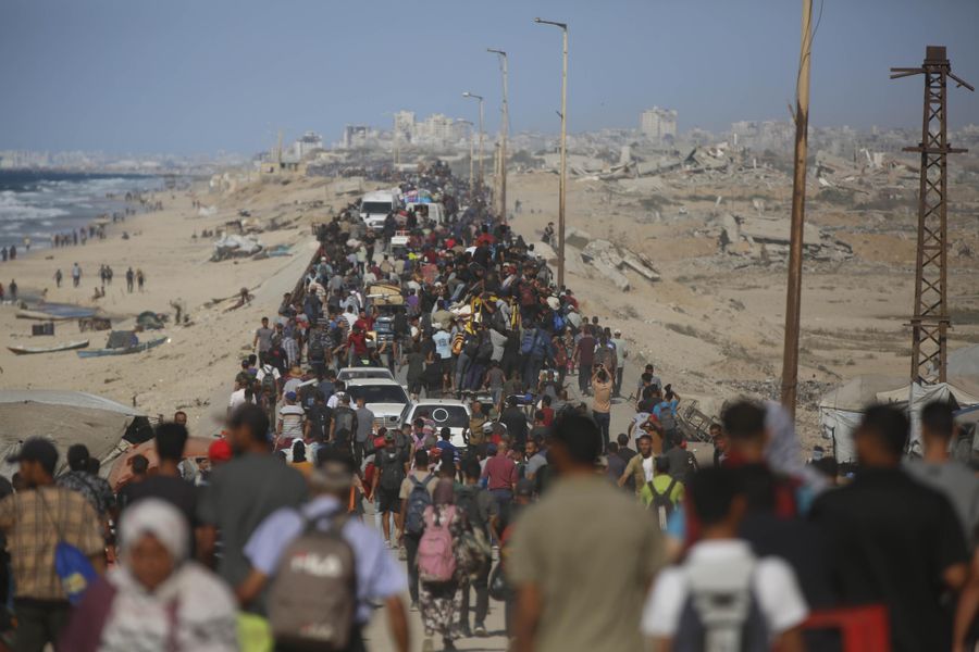 戦闘停止となった11月10日、荷物を持ってガザ北部へもどるパレスチナ人ら(ゲッティ=共同)