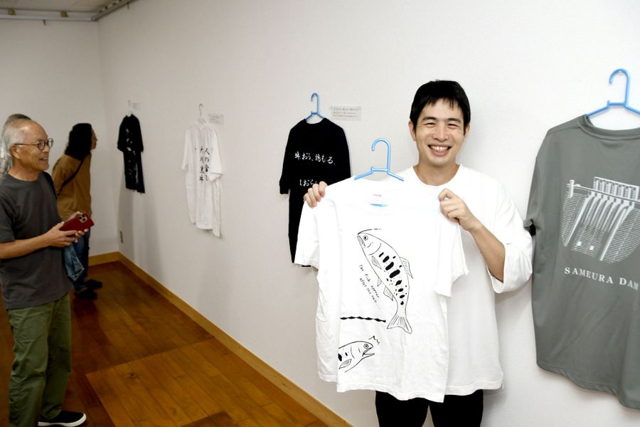 道の駅をイメージしたTシャツをデザインした有坂亮祐さん(右)の作品展=土佐町の郷土学習センター