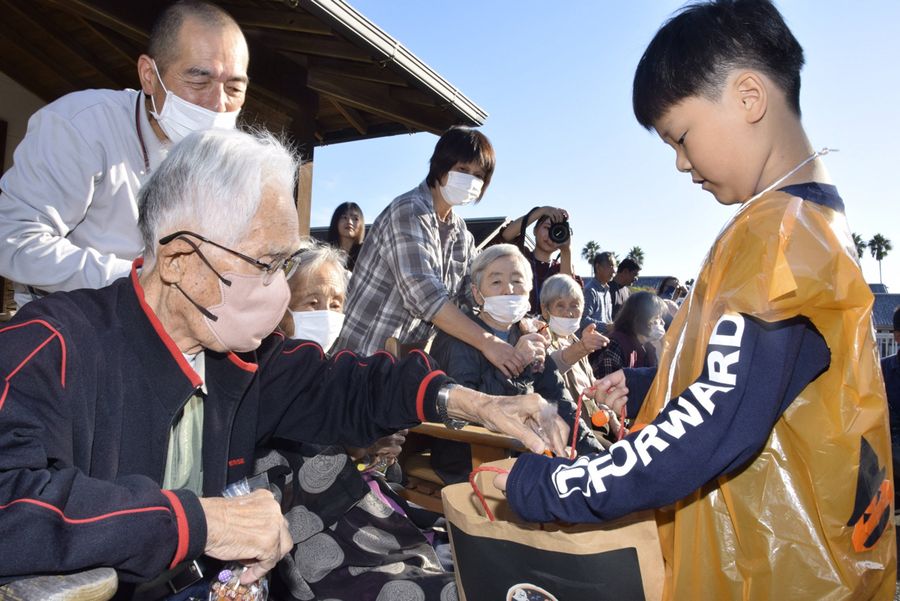 お年寄りから菓子をもらう子どもたち(安芸市の「託老所わすれな草」)
