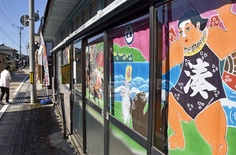 店舗の窓ガラス越しに飾られた伝統フラフ（香美市香北町美良布）