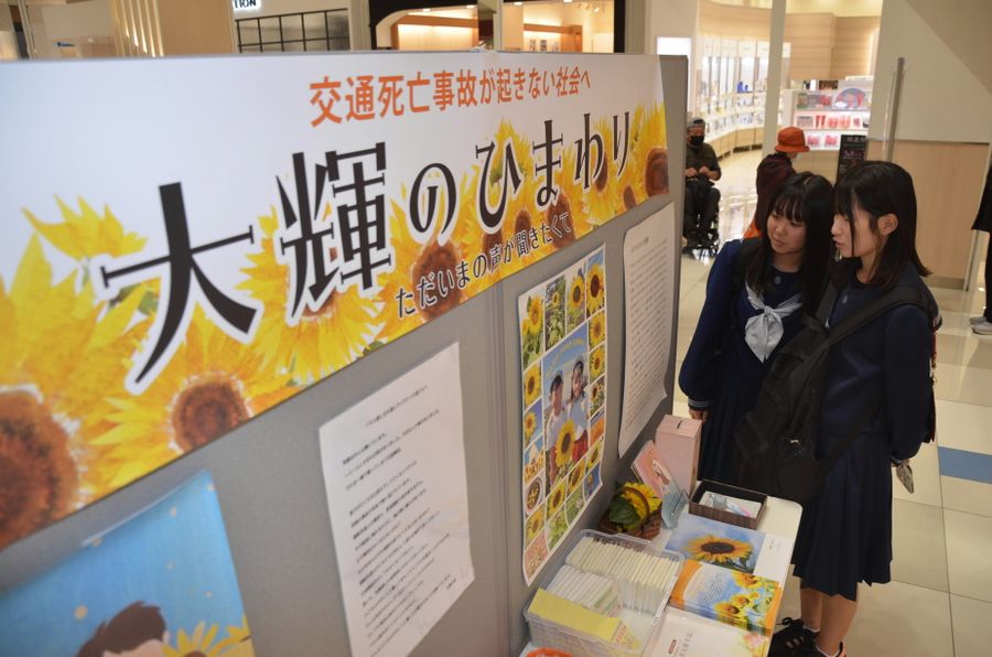 交通事故被害者家族のメッセージパネルに見入る来場者(高知市のイオンモール高知)