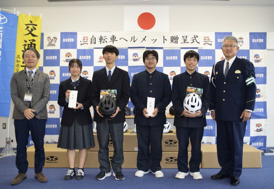 ヘルメットを受け取った宿毛高校と宿毛工業高校の生徒ら（宿毛市希望ケ丘の宿毛署）