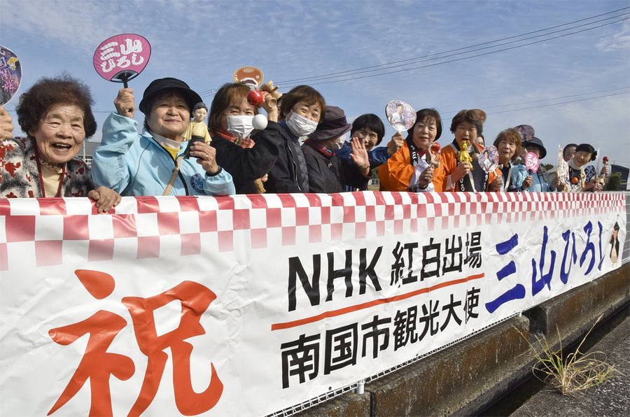 三山ひろしさんの紅白出場を祝う横断幕を掲げ、声援を送るファンたち（南国市下末松）