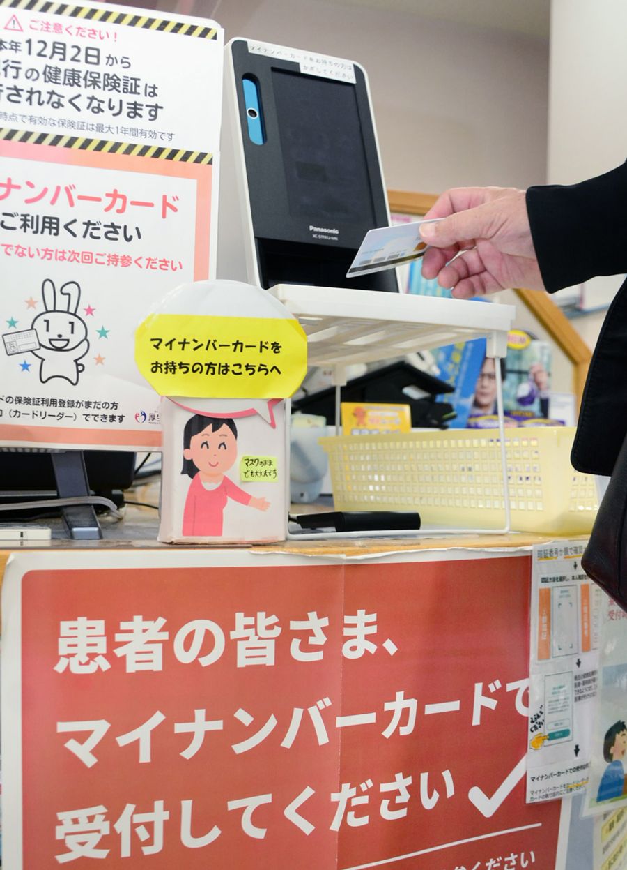 薬局でマイナ保険証を使って受け付けする患者。現行の保険証は１日で有効期限が切れる（高知市内）