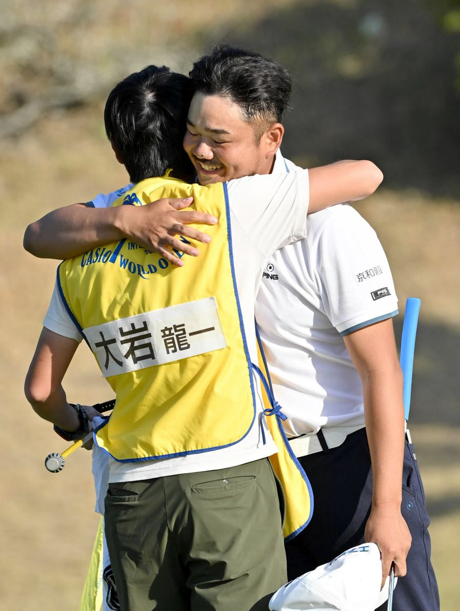プレーオフ２ホールの激戦を制した大岩龍一＝右。キャディーと抱き合い、ツアー初優勝を喜ぶ（黒潮CC=河本真澄撮影）