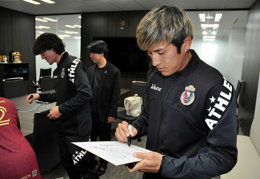 色紙にサラサラとペンを走らせる新谷