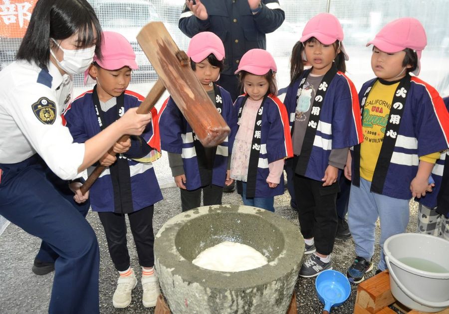 「よいしょ!よいしょ!」のかけ声に合わせて署員と餅をつく園児たち(高知市の高知南署)