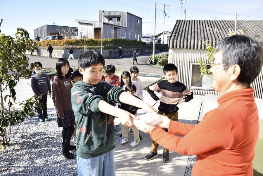 つきたての餅を住民に手渡す子どもたち（田野町の大野台地）