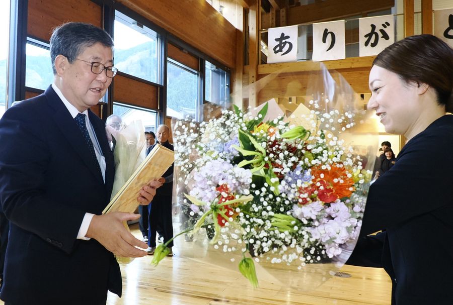 花束を贈られる吉田尚人町長＝左（梼原町役場）