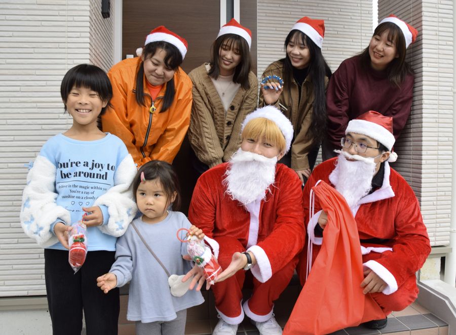 サプライズで姉妹を訪問し、お菓子をプレゼントした若者ら（田野町の上ノ岡団地）