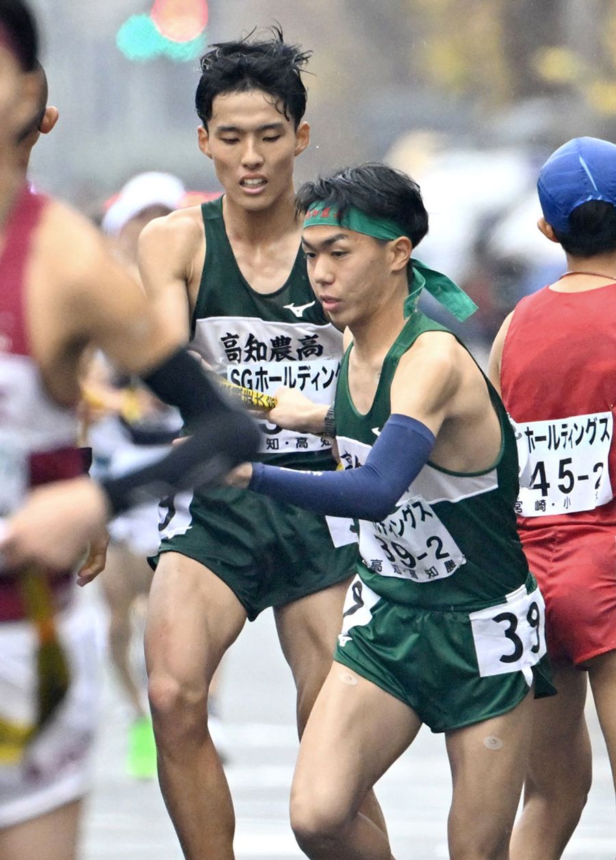 【男子】高知農の１区・山本聖也＝奥＝が１１位で２区・浜口碧月にたすきを渡す（京都市上京区の第１中継所＝写真はいずれも森本敦士撮影）