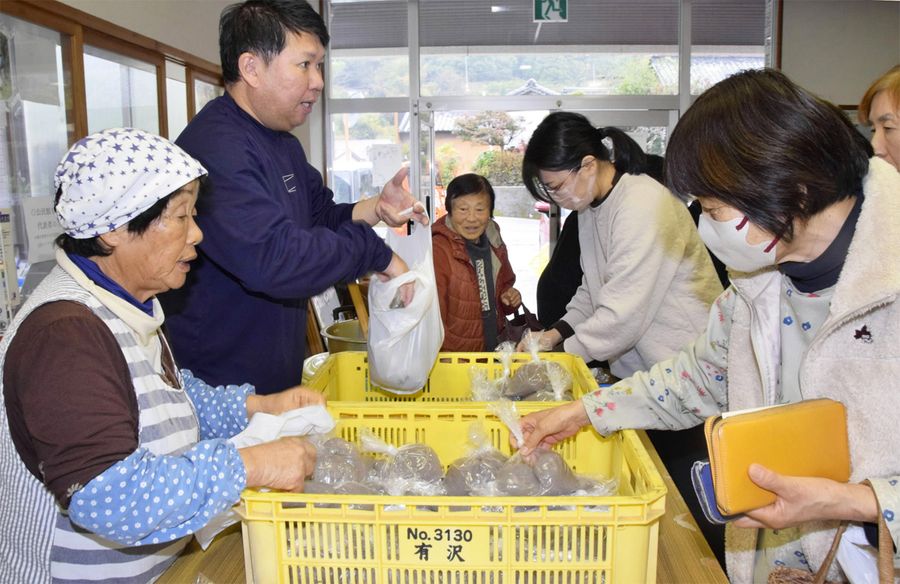 ふれあい市に並んだこんにゃくなどを買い求める来場者（安芸市の東川公民館）