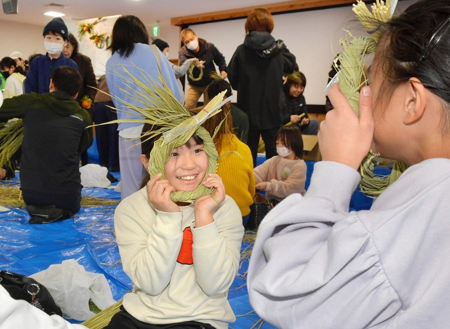 作ったしめ縄を友達同士で見せ合う児童ら（高知市の木村会館）