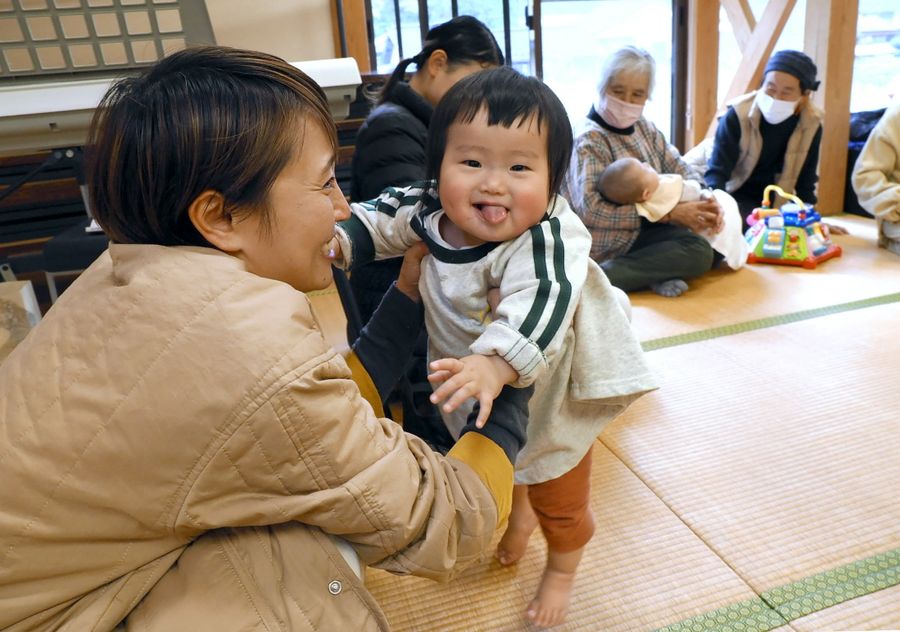 「ママだ！」。おばあちゃんの膝から一目散にはいはいしてきた神明燈季ちゃん。ママの笑顔も明るい（梼原町）