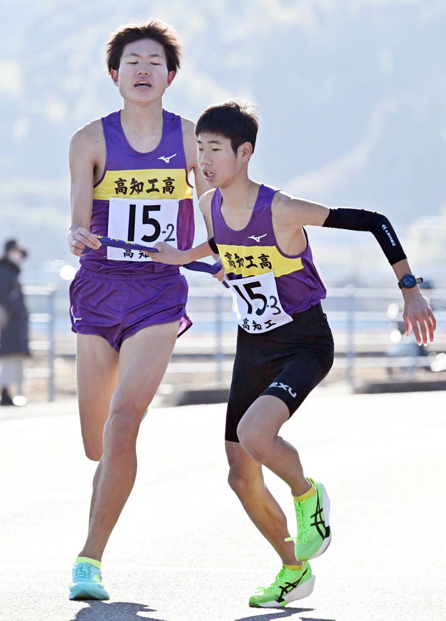 高知工高Ａの２区平尾大空＝左＝が３位に順位を上げ、３区北川歩夢にたすきをつなぐ （ＩＮＯＵＥ東部スポーツパーク周回コース＝森本敦士撮影）