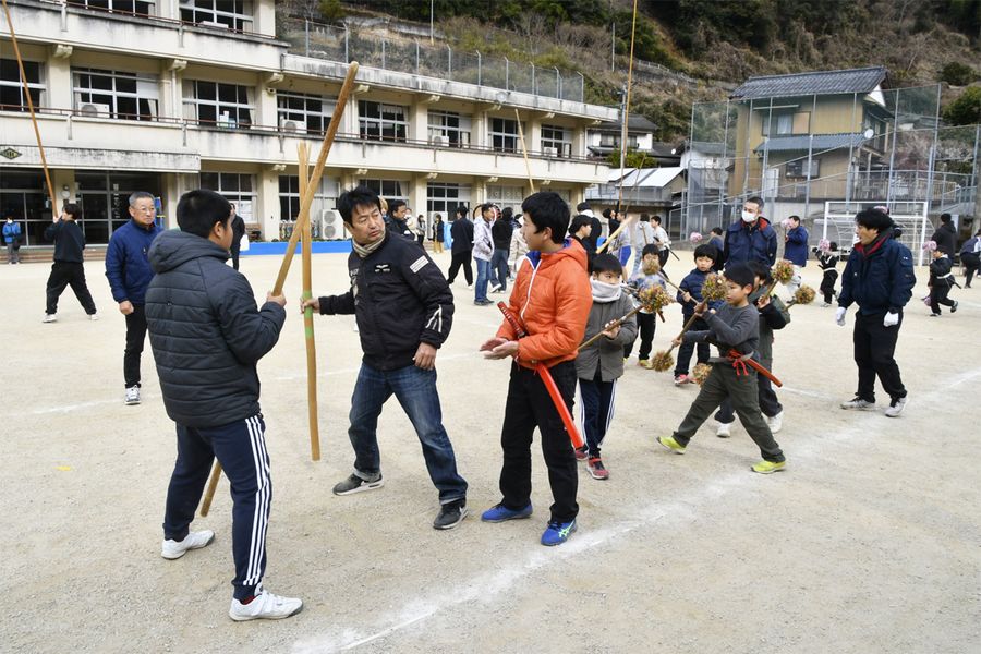 秋葉まつりに向け、大人たちの指導を受けながら太刀踊りの技を磨く子どもら(仁淀川町の別府小学校)