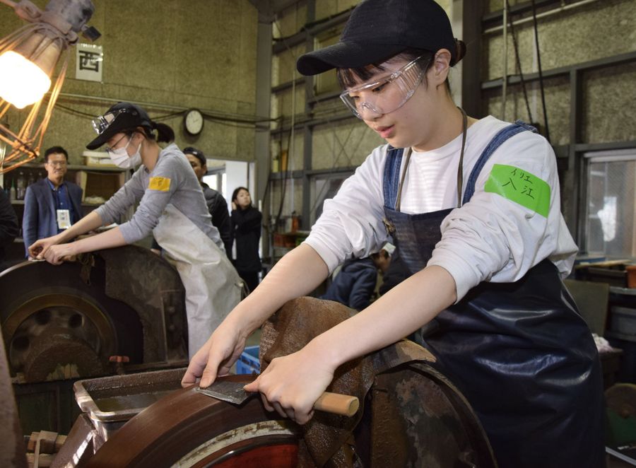 包丁作りに取り組む留学生ら（香美市土佐山田町上改田の鍛冶屋創生塾）