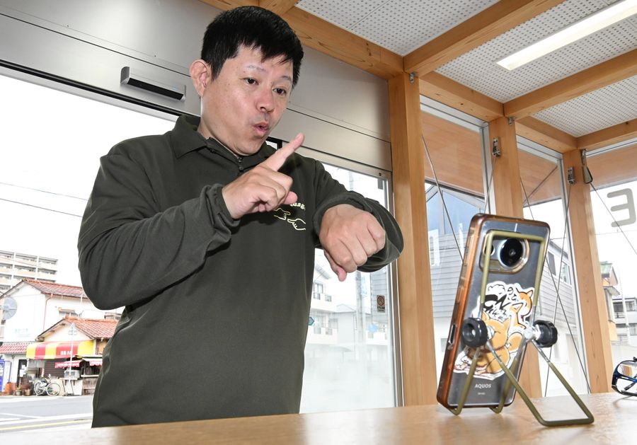 手話リンクを体験する川村公一郎さん（高知市神田の鴨田交番）