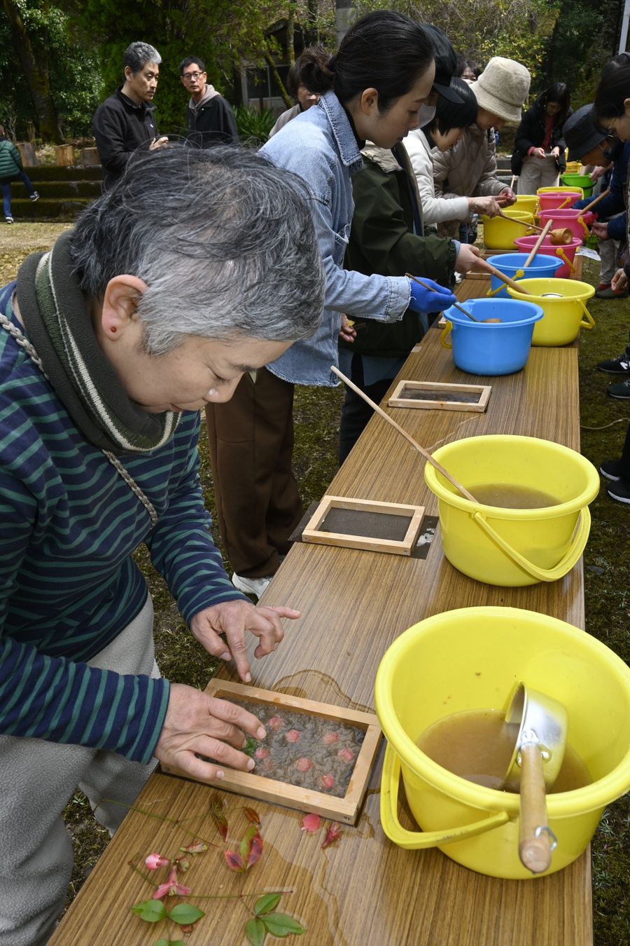 黒尊川流域のミツマタを原料にした和紙づくり体験を楽しむ参加者（四万十市西土佐玖木の玖木公民館）