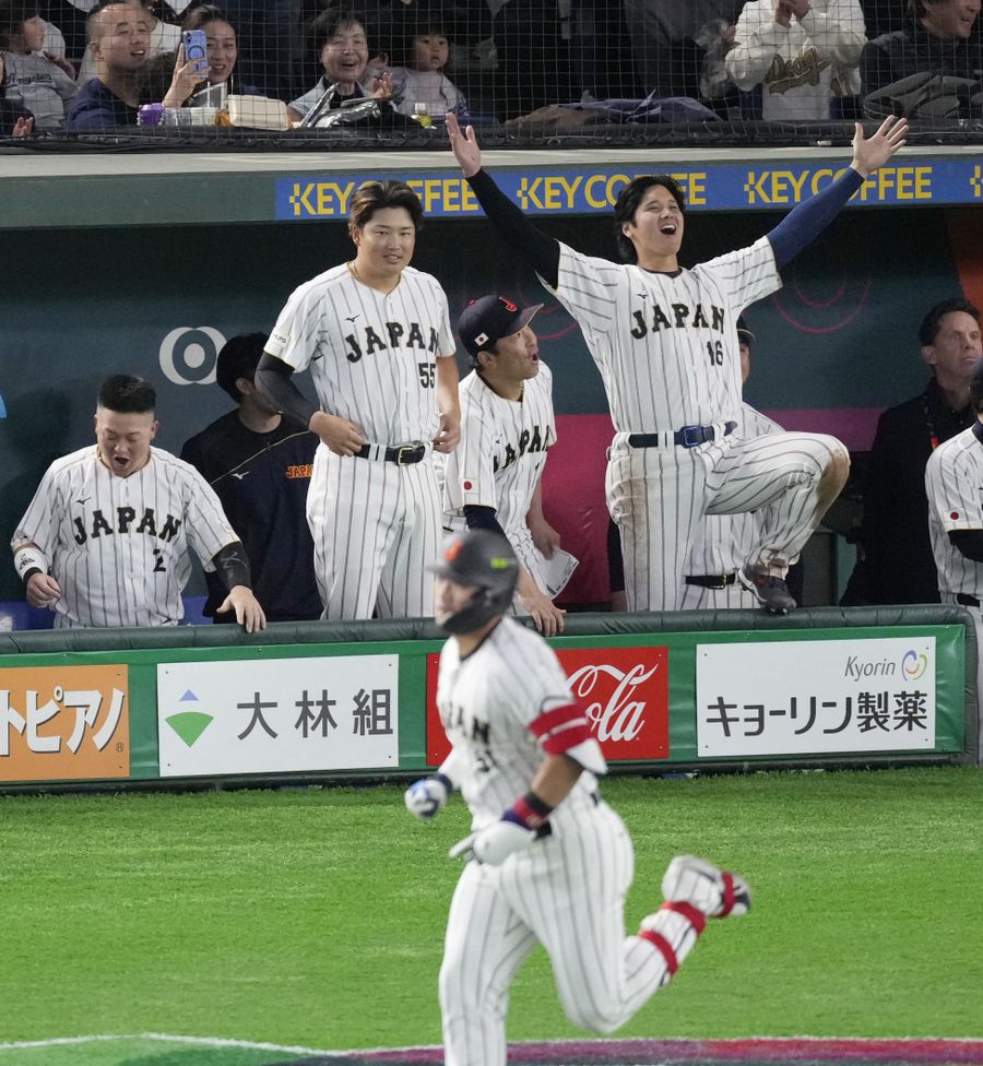 韓国戦で鈴木誠也選手（手前）の２打席連続ホームランに喜ぶベンチの大谷翔平選手（右はし）＝７日、東京ドーム