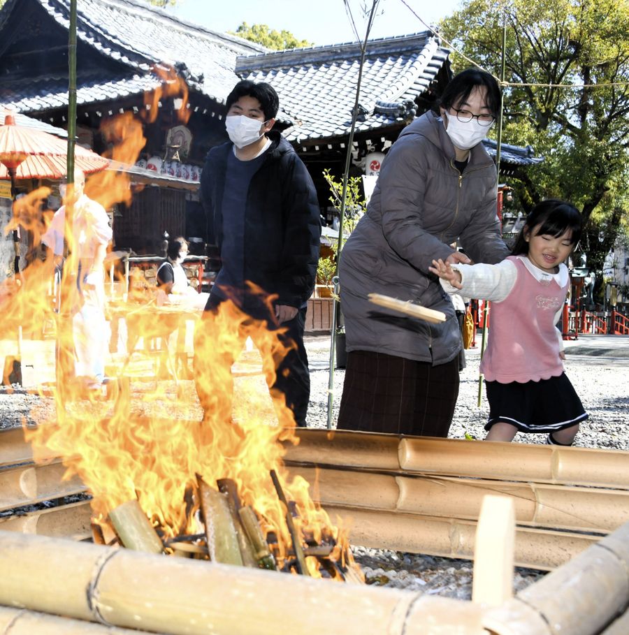 長年愛用した箸を炉に投げ入れる家族連れら(高知市の高知八幡宮)