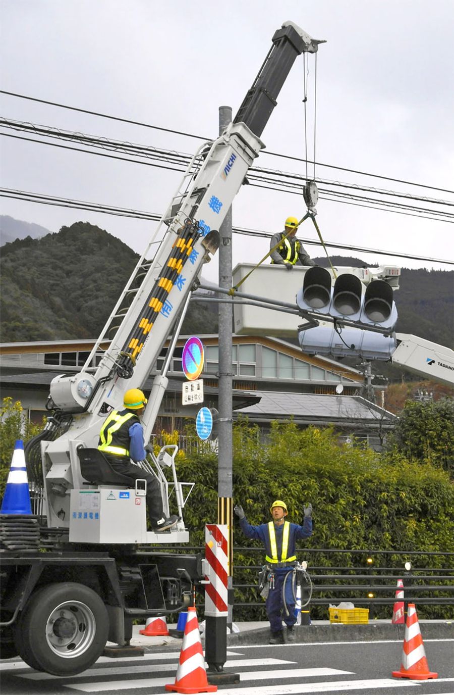 「交通量の減少」を理由に撤去される信号機。新たに「横断者注意」の文字が路面に塗装された(本山町本山)