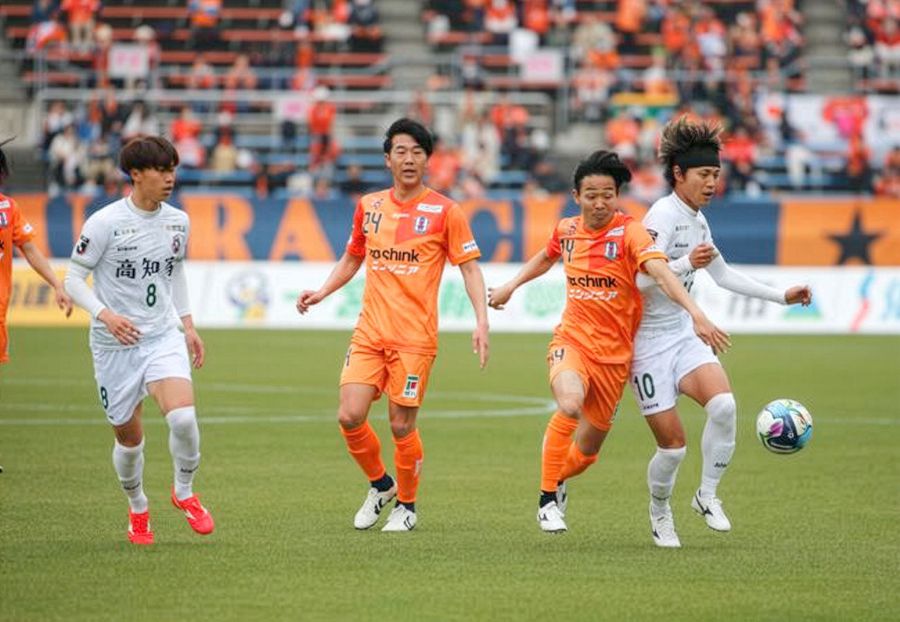 【愛媛―高知U】前半、ボールを奪い合う高知の佐々木(10)=ニンジニアスタジアム