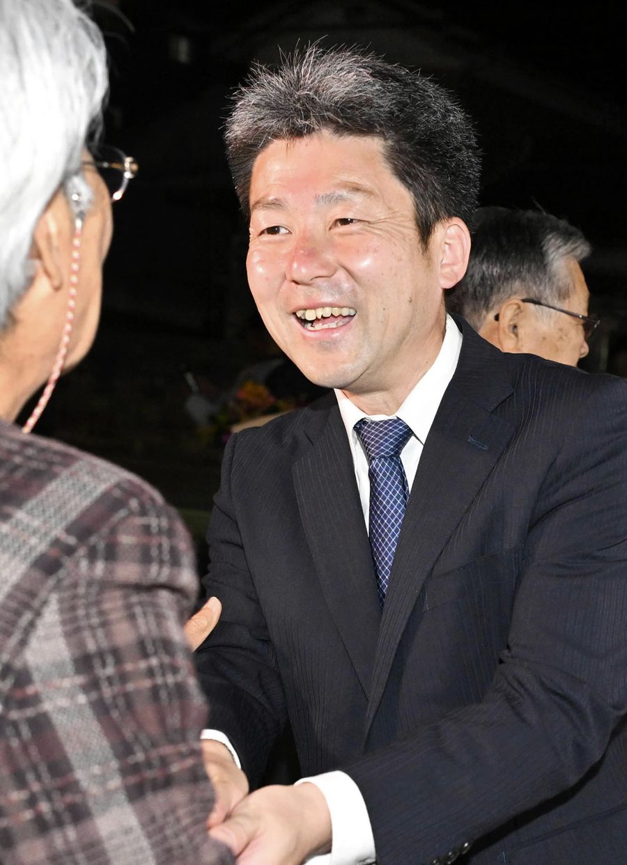 再選を決め、支援者と握手する依光晃一郎氏（香美市土佐山田町楠目）