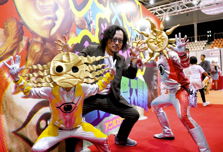 タローマンの藤井亮監督＝中央＝と「地底の太陽」のコスプレをした辻ノ内八雲さん＝左。タローマンのコスプレは父の祐太さん（４月、高知市の県民体育館＝横田宰成撮影）