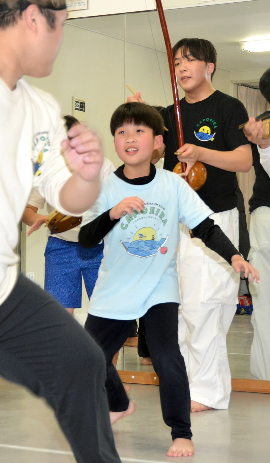 いとこの煌羽さん＝左＝とカポエイラを楽しむ大崎瑛斗さん。後方はいとこの那煌さん（高知市升形）