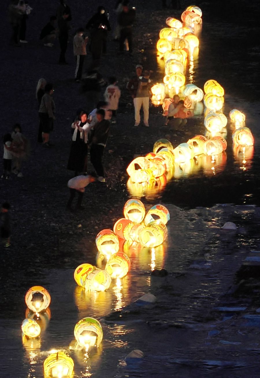 河原近くで幻想的に光る紙のこいのぼり（いの町波川＝森本敦士撮影）
